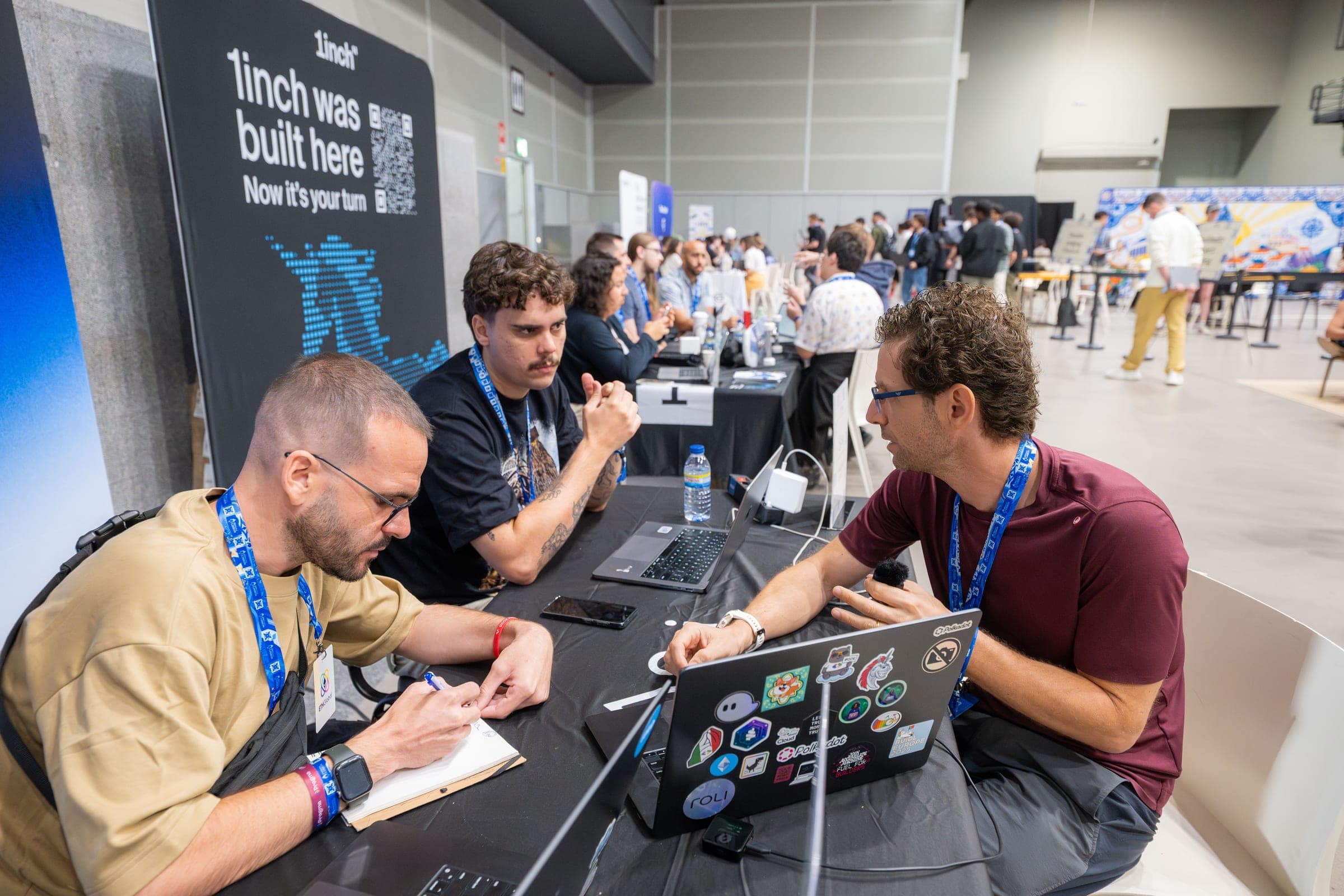 Guilherme and two mentors review a project with a builder at the Sui table at ETHGlobal Lisbon.