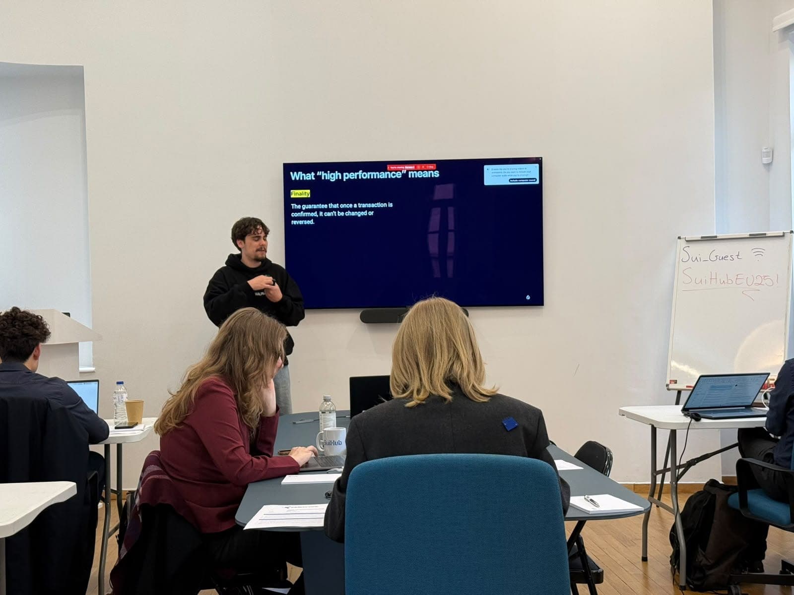 Guilherme presents a slide about transaction finality to a workshop room at SuiHub Athens.
